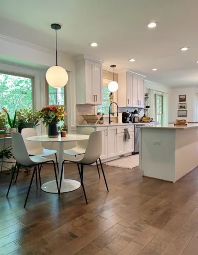 A kitchen with hardwood floors and a dining table.
