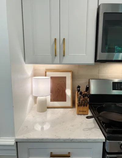 A kitchen with white cabinets and a microwave.