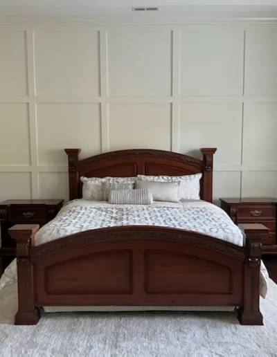 A bedroom with a bed, dresser, and mirror.