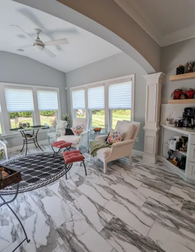 A living room with marble floors and a fireplace.