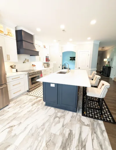 A kitchen with marble floors and a large island.