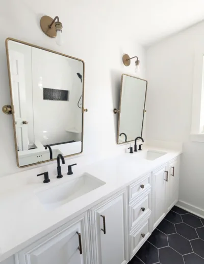 A white bathroom with two sinks and a mirror.