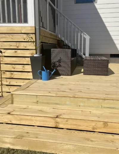 A wooden deck with steps and a hot tub.